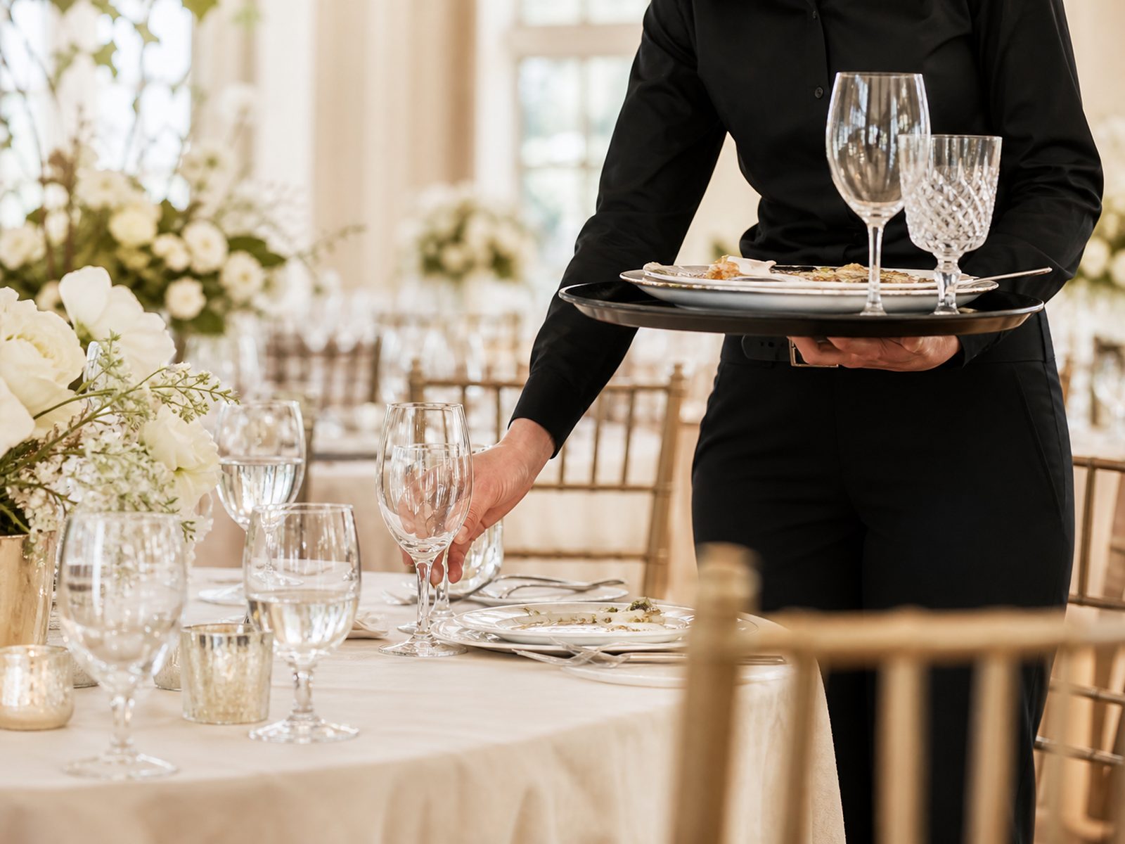 Illustrative photo of event staff clearing and resetting a dining table